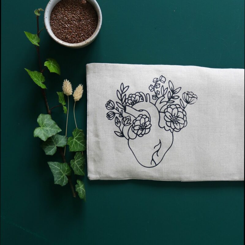 Grande bouillotte en graines de lin Cœur, sérigraphie artisanale symbolisant amour et amitié, utilisable chaud ou froid, housse lavable, fabrication française.