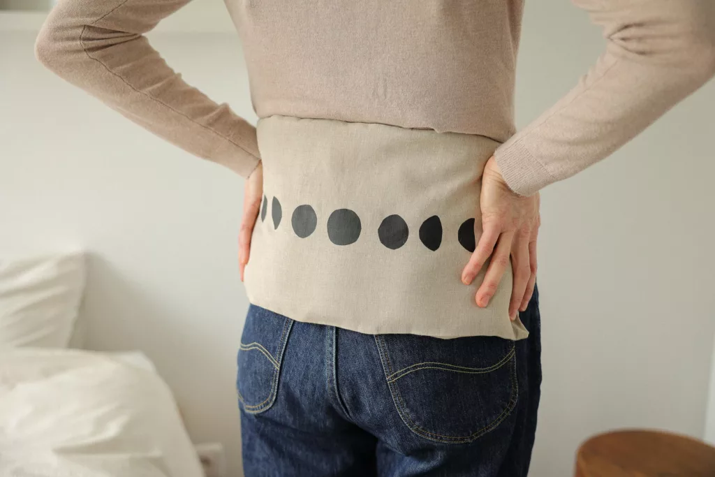 bouillotte en graines de lin posée sur le dos pendant les règles