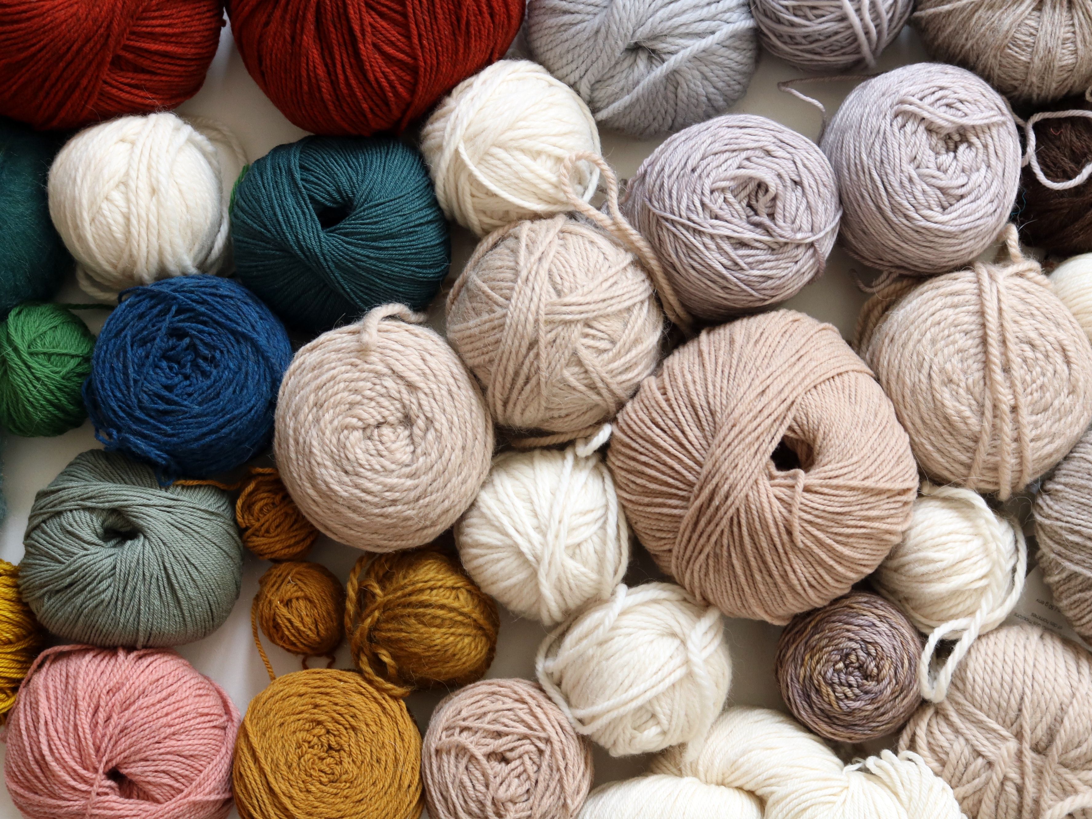 Pelotes de laine colorées posées sur une surface en bois, stock de laine tricot crochet
